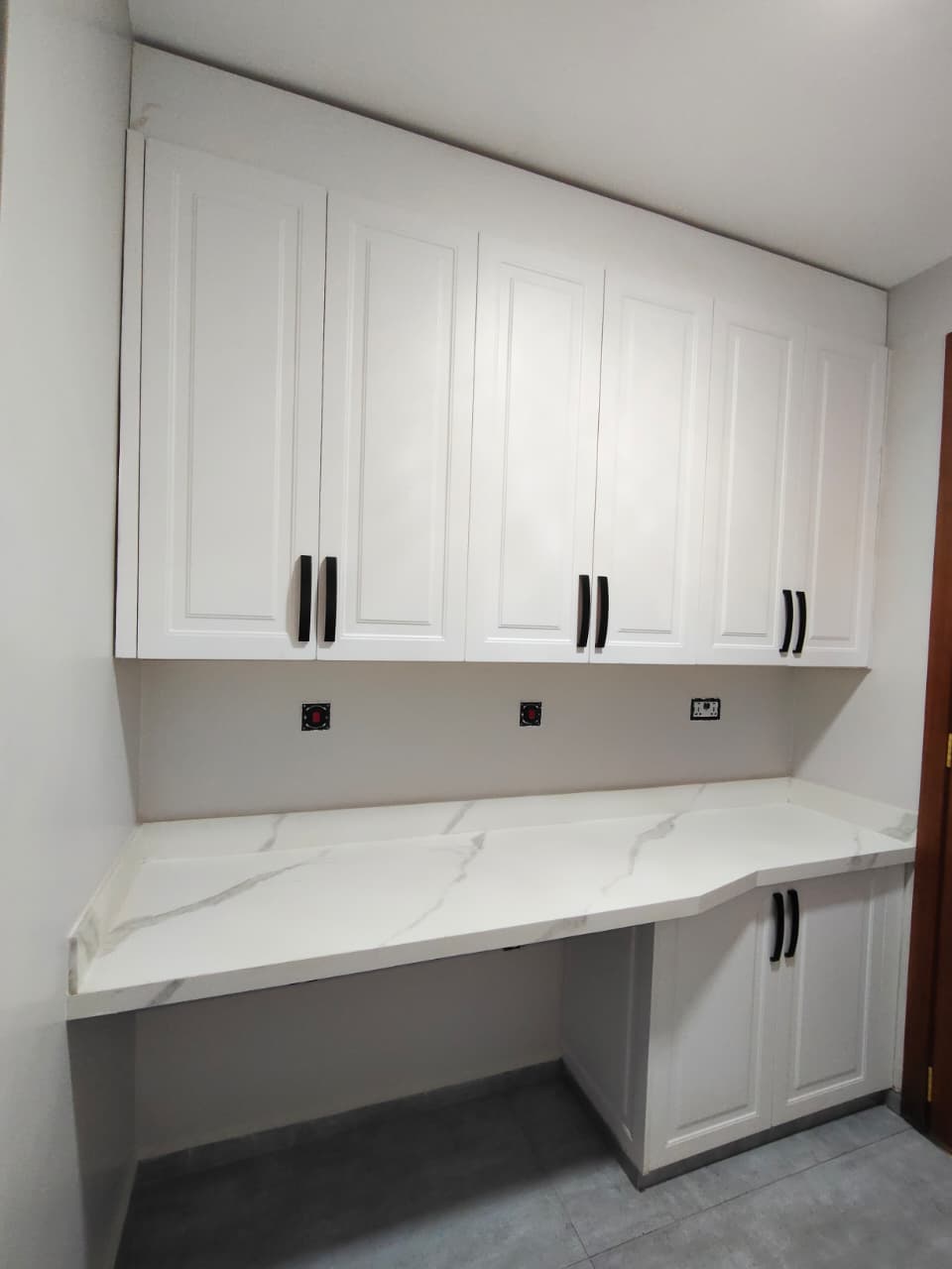Custom built-in cabinetry with marble desk countertop