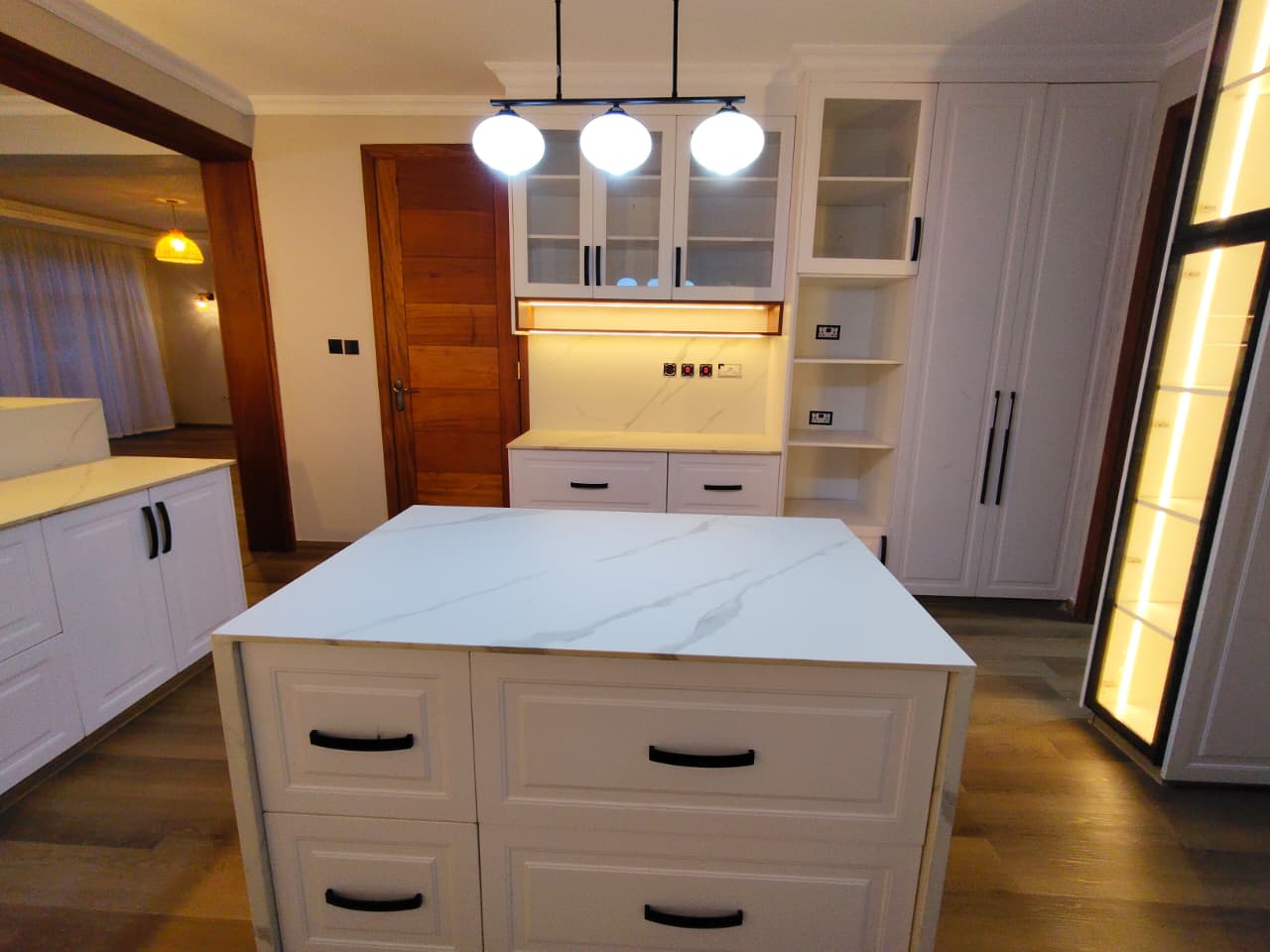 Custom white kitchen island cabinetry with marble countertop